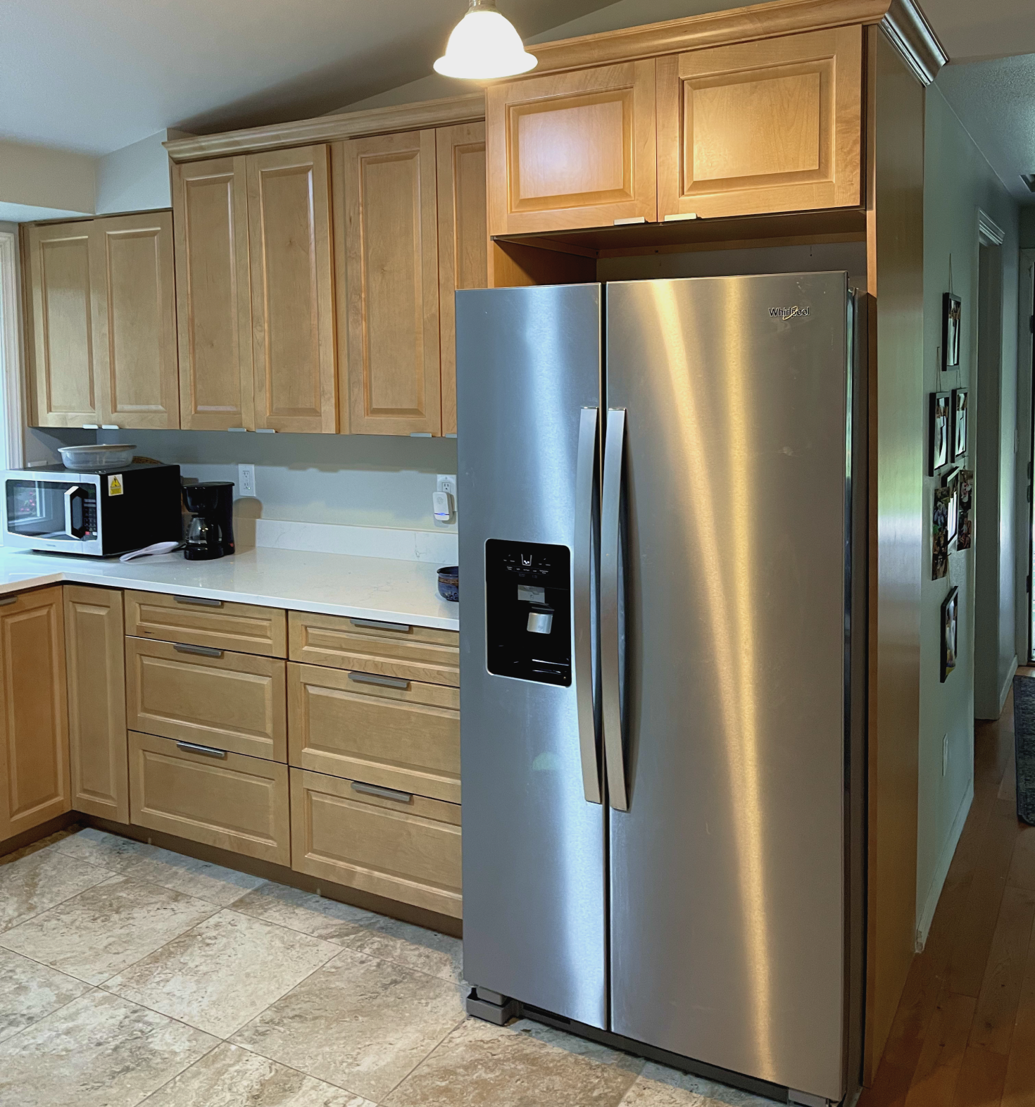 a kitchen with a refrigerator and wooden cabinets